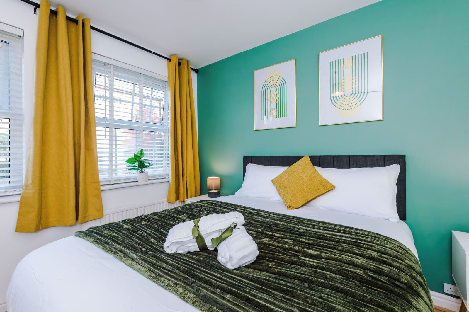 Double bedroom made up with fresh white bedding and folded towels ready for an arrival
