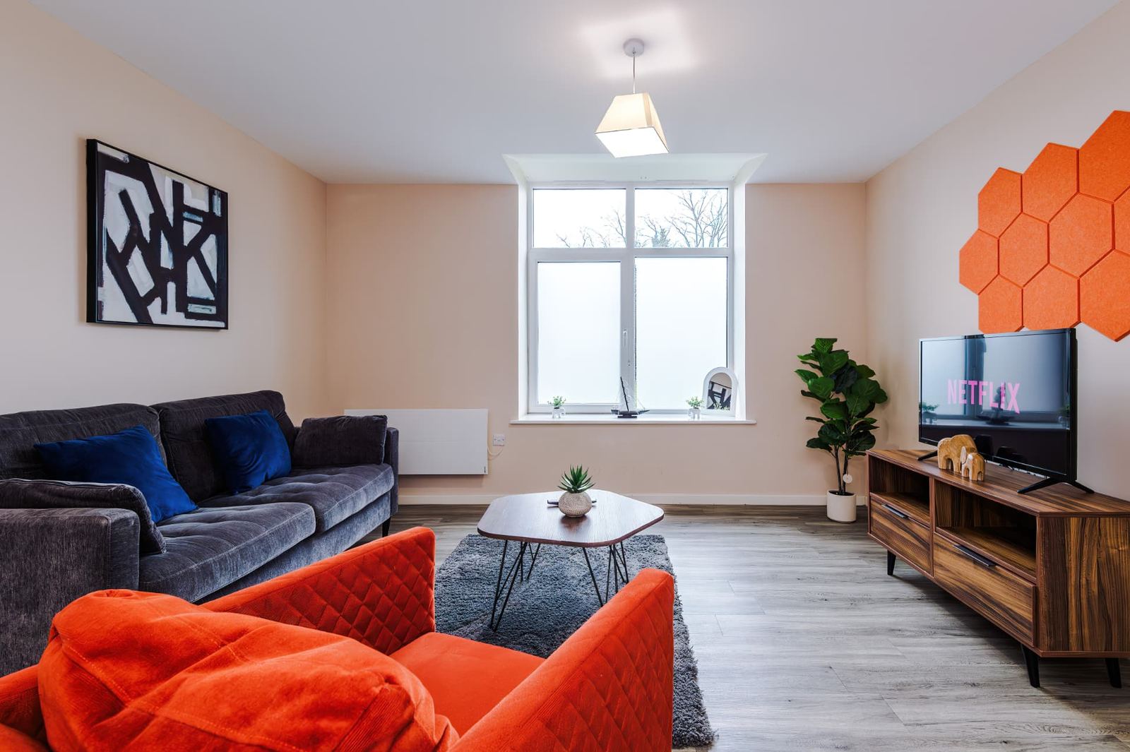 Furnished apartment living room with sofas, coffee table and wall-mounted television