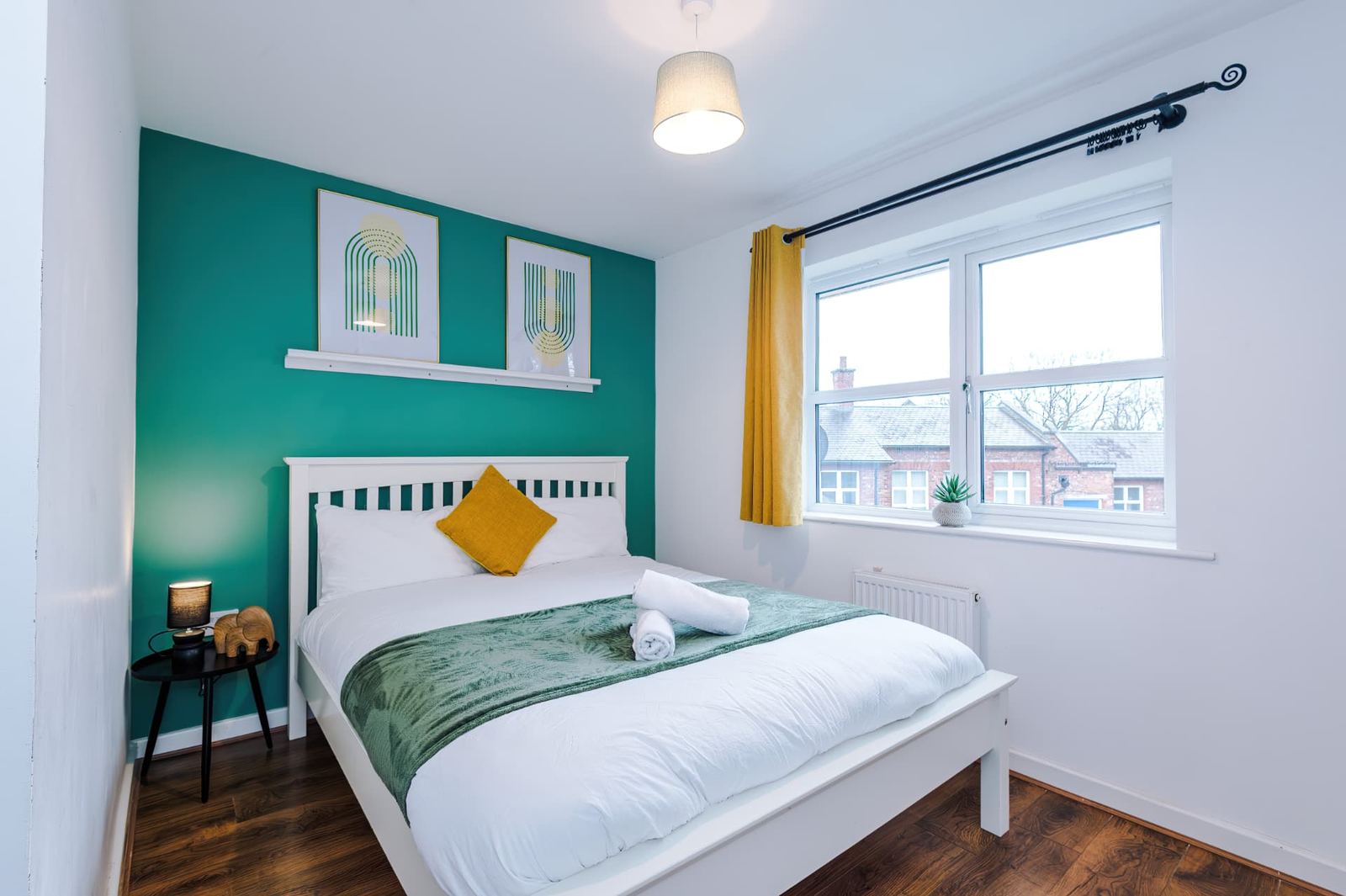Furnished double bedroom in a residential property, with a window looking on to nearby houses